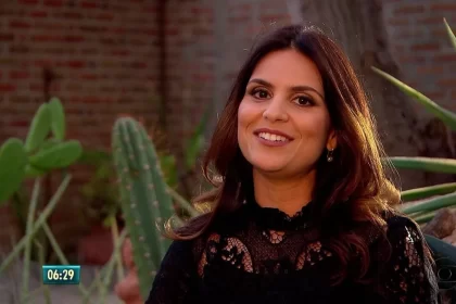Aline barros veste preto e sorrir para a câmera durante reportagem na tv globo