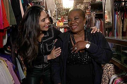 Daniela Albuquerque abraça Neusa Borges enquanto caminham numa feira em matéria especial do Sensacional na RedeTV!