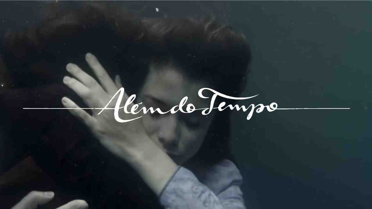 Protagonistas da novela Além do Tempo abraçados e submersos no mar. O logo da novela está por cima
