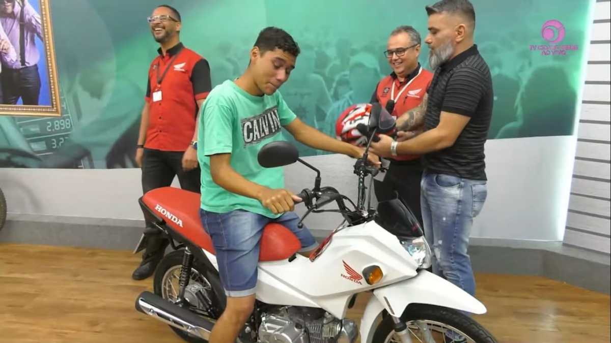 Luiz sobre na moto que ganhou no programa Pop Show