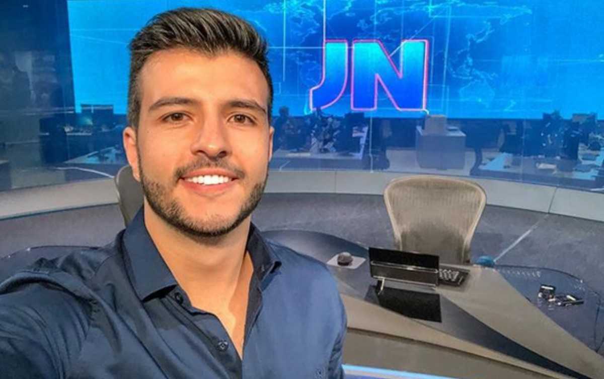 Foto do jornalista Matheus Ribeiro no estúdio do Jornal Nacional