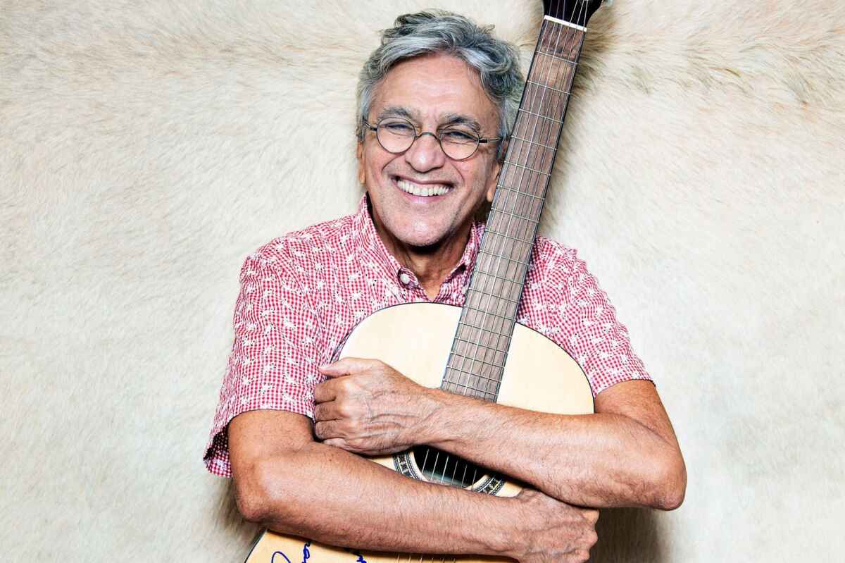 Cantor Caetano Veloso com um violão nas mãos