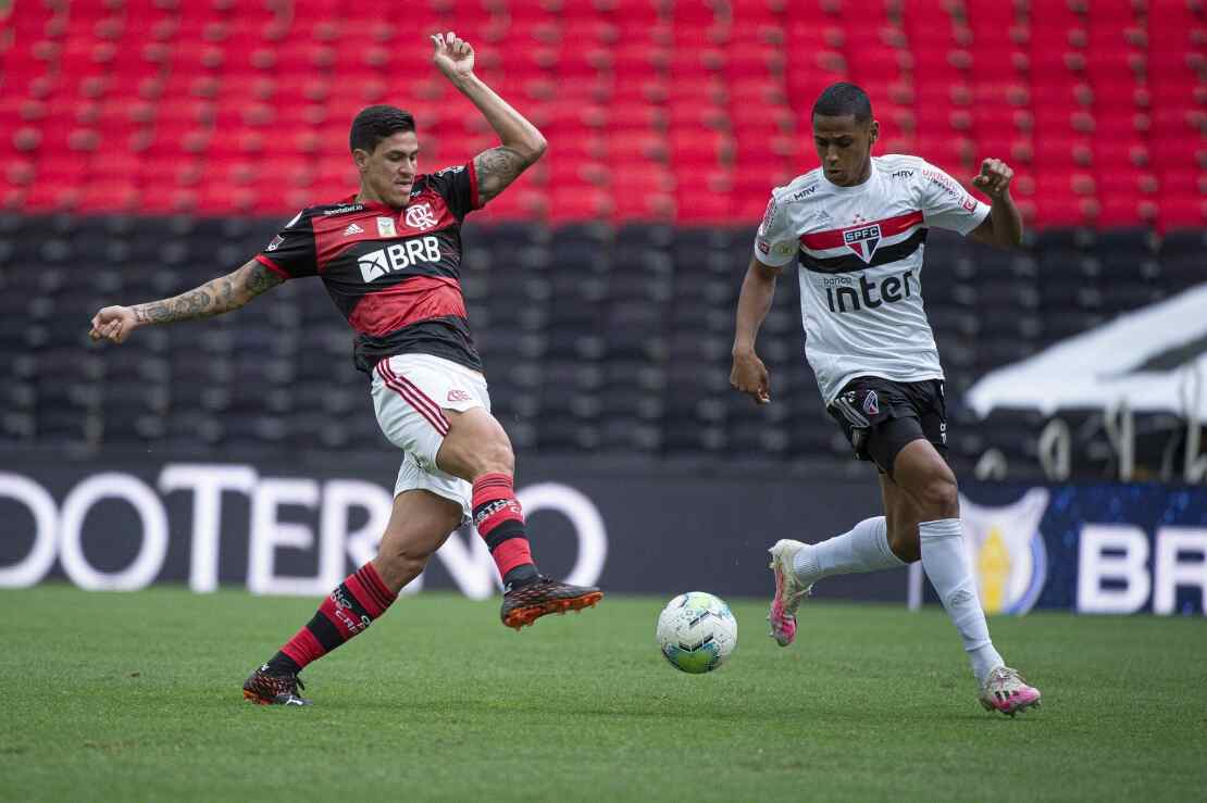 Jogadores de Flamengo e São Paulo disputando uma bola no jogo do turno do Campeonato Brasileiro