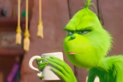O Grinch segurando uma xícara branca nas mãos