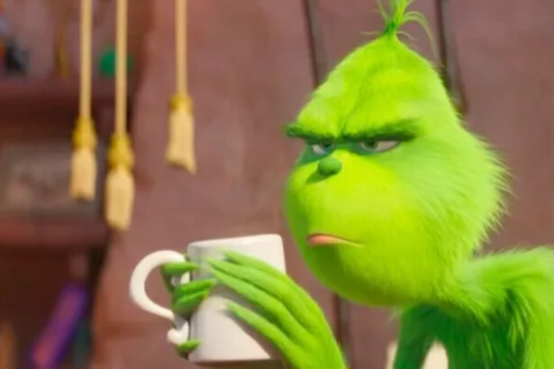 O Grinch segurando uma xícara branca nas mãos