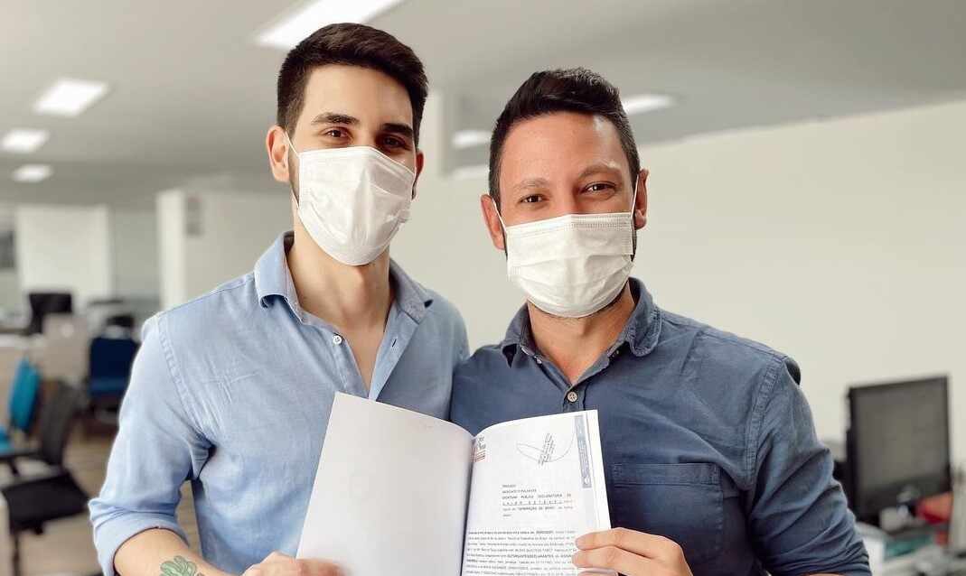Edivaldo Dondossola e namorado no cartório segurando a certidão de casamento