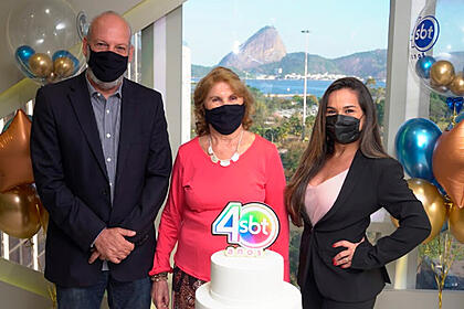 Gerente comercial Mario Rigon, Sara e Isabele em frente ao bolo do SBT do Rio