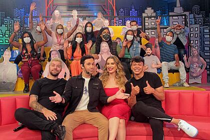 Júlio cocielo, victor sarro, viny vieira e fernanda keulla sentados em um sofá, nos estúdios do encontro, com a plateia ao fundo, utilizando máscara