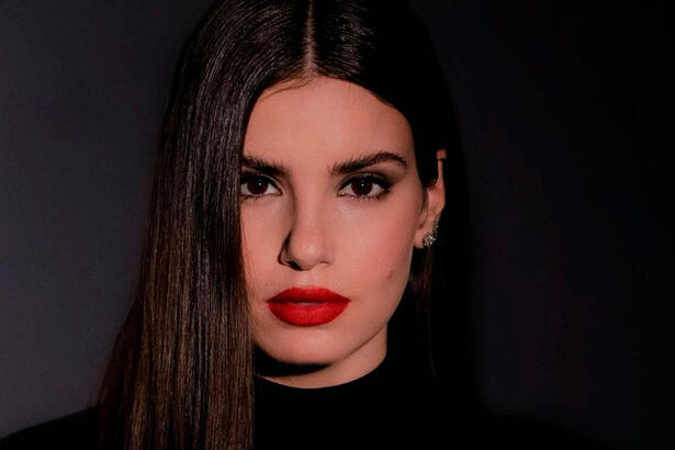 Camila Queiroz usa batom vermelho e roupa preta
