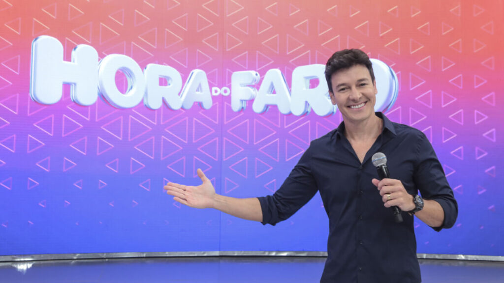 Rodrigo Faro em frente ao telão nos estúdios do Hora do Faro