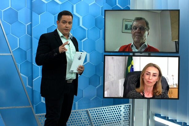 Apresentador Eduardo Miranda com um tablet na mão em trecho do Aparecida Debate de 25 de janeiro
