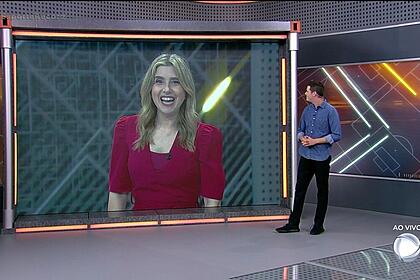 Fred Ring nos estúdios do Esporte Record em São Paulo, olhando para o telão que mostra Mylena Ciribelli nos estúdios do programa no Rio de Janeiro