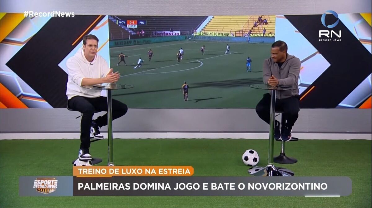 Fred Ring e Müller sentados nos estúdios do Esporte Record News, em frente ao telão de led