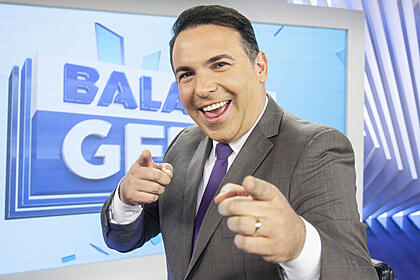 Reinado gottino, nos estúdios do balanço geral, sorrindo e apontando para a câmera