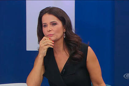 Adriana araújo com a mão por cima da bancada do programa canal livre