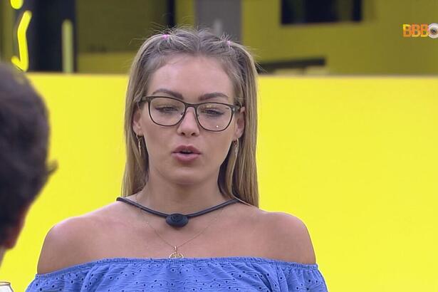 Bárbara de blusa azul sentada na mesa do Almoço do Anjo do BBB 22