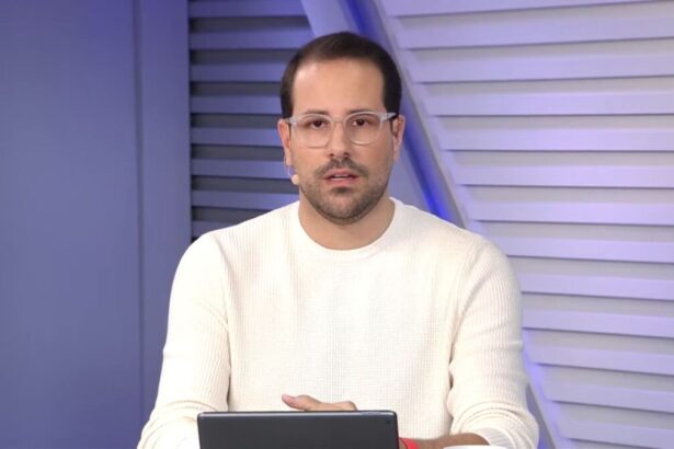 Paulo Mathias de moletom branco lendo um editorial no programa Morning Show, na rádio Jovem Pan