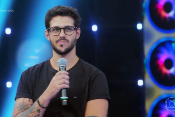 Rodrigo de óculos com microfone na mão no Domingão com Huck