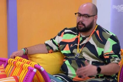 Tiago sentado na área externa do BBB 22.