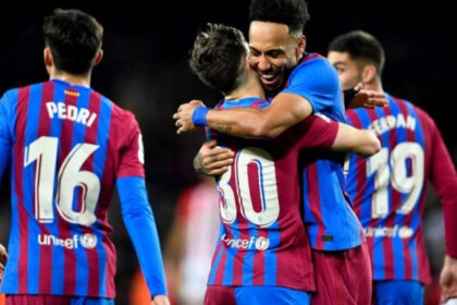 Jogadores em campo e comemorando um gol com a camisa do Barcelona