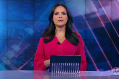 Márcia Dantas, com uma blusa rosa, sentada na bancada do SBT Brasil - edição de 18 de março de 2018