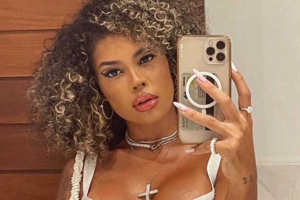 Sthe Matos em um selfie no espelho no banheiro com o celular em uma das mãos a mostra