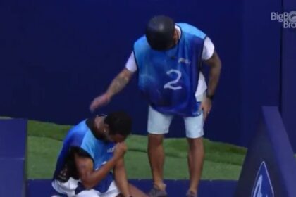 Paulo André de cabeça baixa e Scooby em pé ao seu lado.