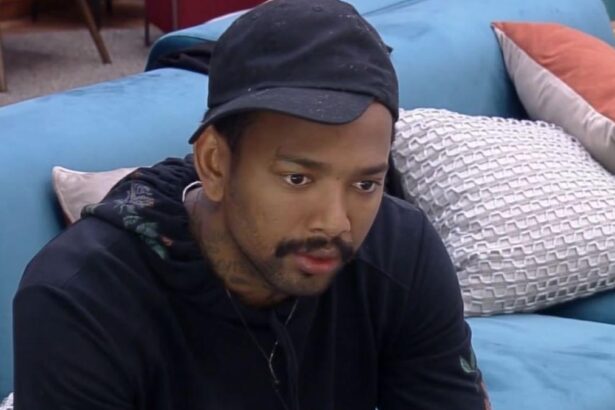 Nego do Borel sentando na sala de A Fazenda 13, durante a sua participação no reality