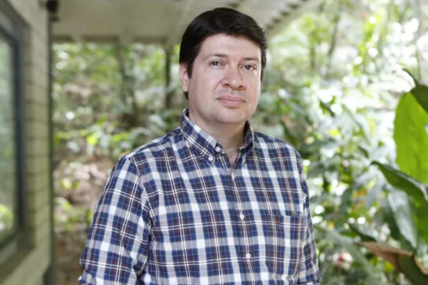 Daniel Adjafre em foto posada na Globo, com um jardim ao fundo