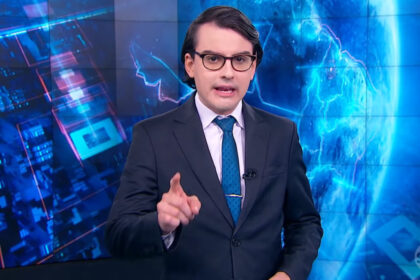 Dudu camargo com o dedo em riste, apontado para a câmera, nos estúdios do primeiro impacto