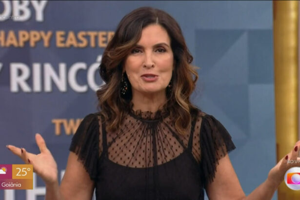 Fátima Bernardes com os braços abertos no estúdio do Encontro, em frente ao telão com a nuvem de palavras