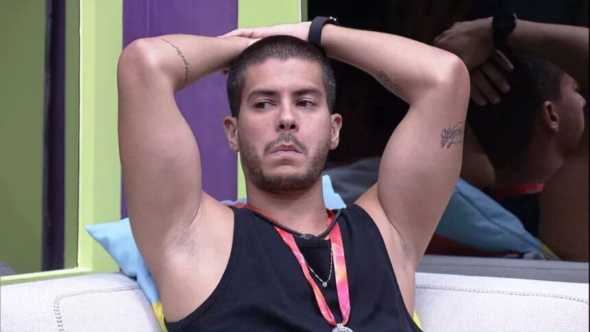 Arthur com os braços na cabeça no sofá do BBB 22.