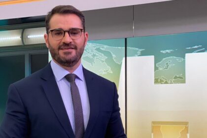 Marcelo Cosme nos estúdios do Jornal Hoje, em frente ao telão