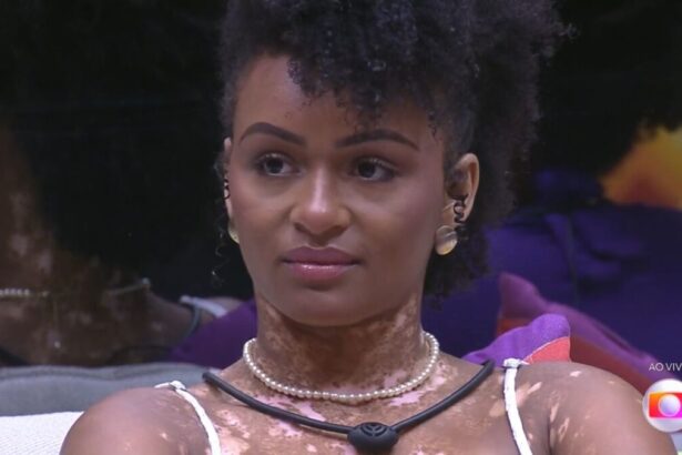 Natália olhando para frente com semblante sério.