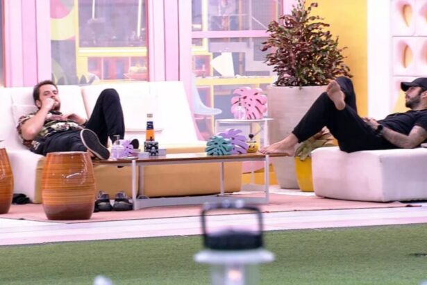 Scooby sentado na área externa do BBB 22 junto de Gustavo.