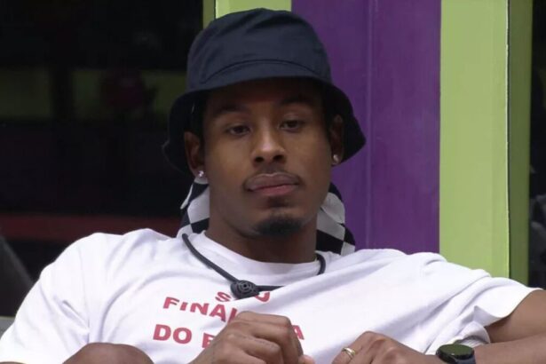 Paulo André de chapéu com semblante sério na sala do BBB 22.