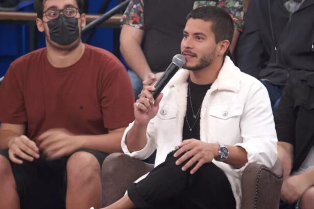 Arthur Aguiar sentado, participando do Altas Horas, no estúdio