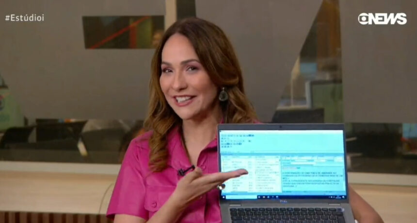 Maria Beltrão com um notebook nas mãos nos estúdios da GloboNews