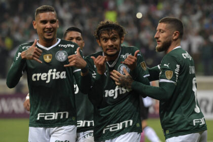 Gustavo scarpa ao lado de jogadores do palmeiras comemorando gol pela libertadores