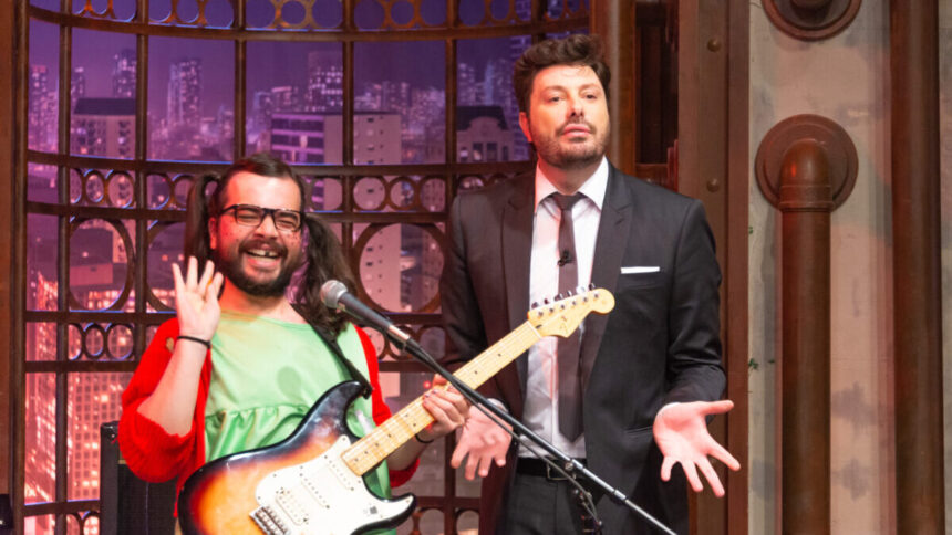 Danilo Gentili ao lado de um ator (interpretado a Chiquinha do Chaves) e tocando guitarra