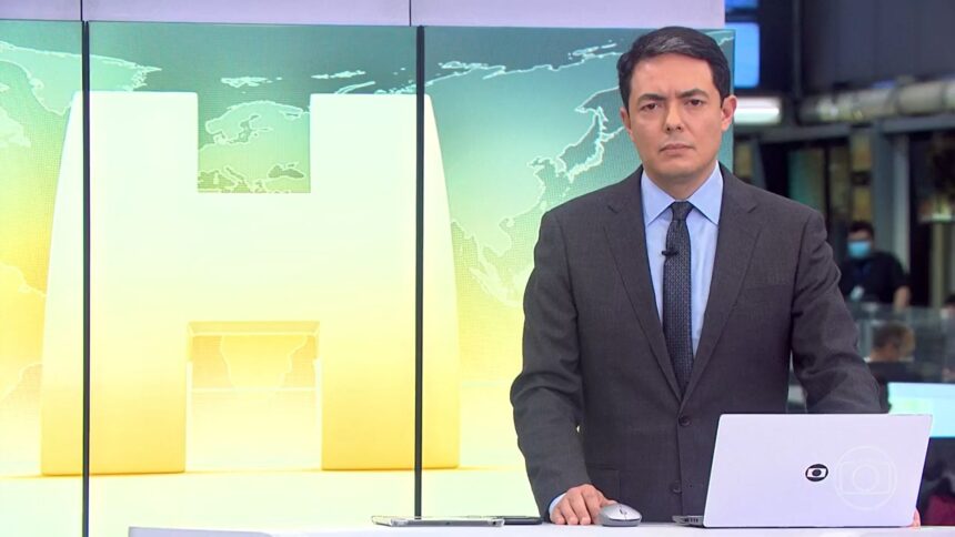 Alan Severiano nos estúdios do Jornal Hoje, posicionado na bancada