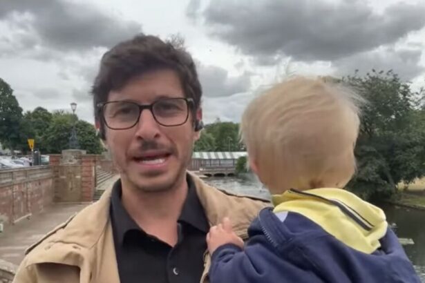 Felipe Kieling fazendo uma entrada ao vivo em um campo aberto e com o filho Lucas no colo