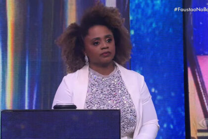 Daiane dos Santos sentada na poltrona, no espaço dos competidores no quadro na Pista do Sucesso