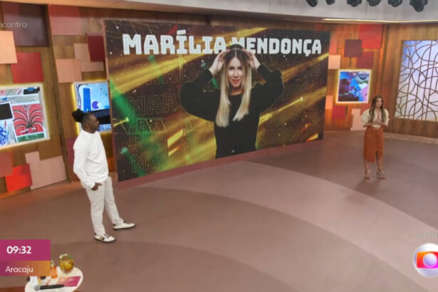 Patrícia Poeta e Manoel Soares nos estúdios do Encontro, em frente ao telão em que está projetada a imagem de Marília Mendonça
