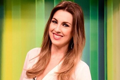 Michelle Giannella de camisa branca, sorrindo, microfone na camisa, durante gravação de programa na TV Gazeta