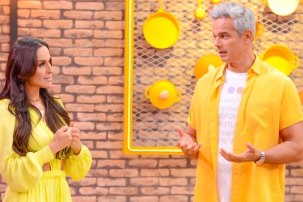 Nadja Haddad de macaquito amarelo, em pé, conversando com apresentador; Otaviano Costa com as mãos em movimento, conversando com Nadja durante gravação