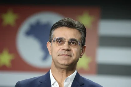 Rodrigo Garcia, em primeiro plano, com a bandeira do estado de SP ao fundo