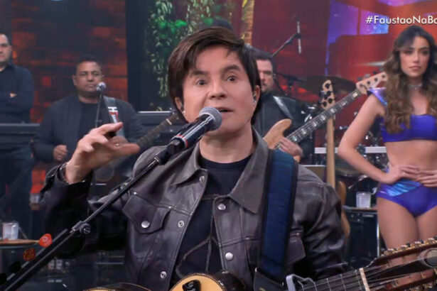 Xororó no palco do Faustão na Band, com um violão no colo, preso ao corpo