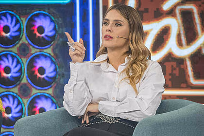 Carolina Dieckmann sentada em uma poltrona, participando do Domingão com Huck