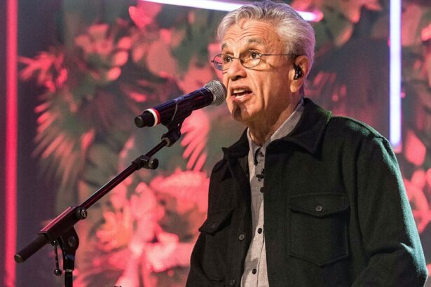 Caetano Veloso com camisa manga longa preta, sentado num banco com o microfone próximo a boca durante gravação do Conversa com Bial da TV Globo